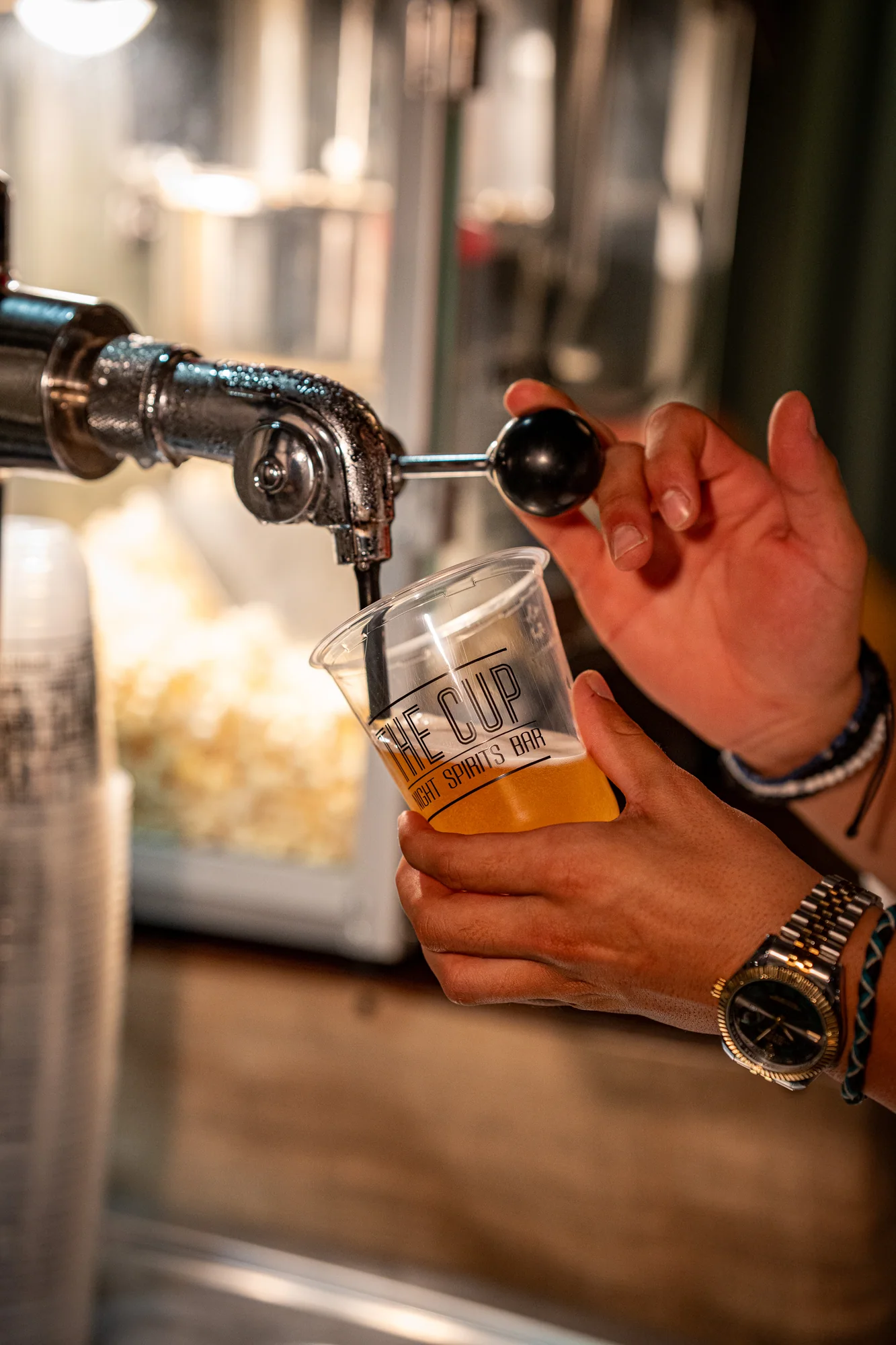 Fresh draught beer being poured into a The Cup branded cup