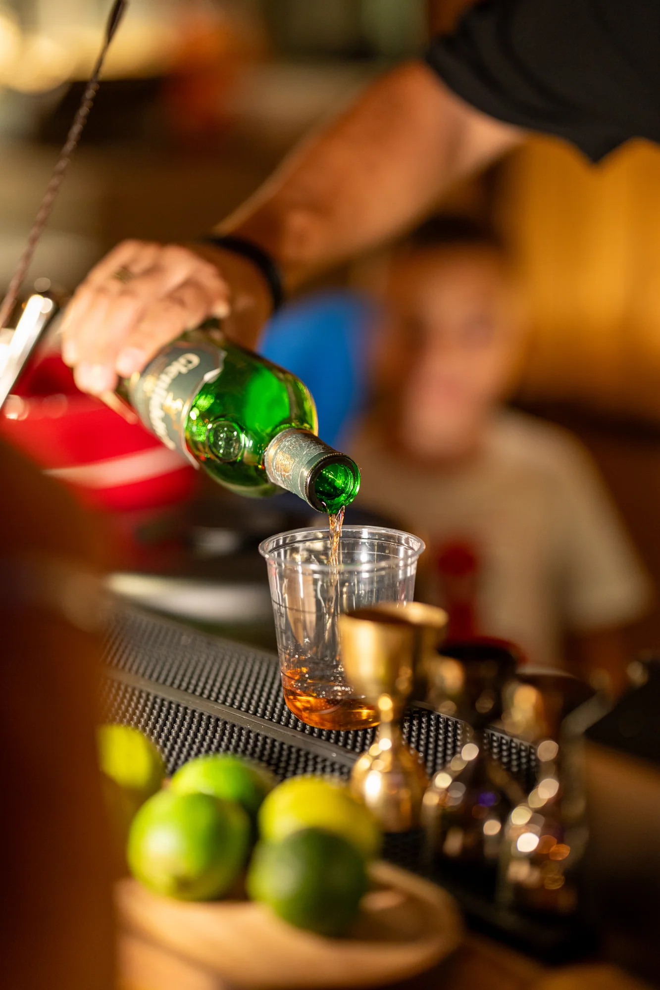 A bartender pouring whisky at The Cup bar
