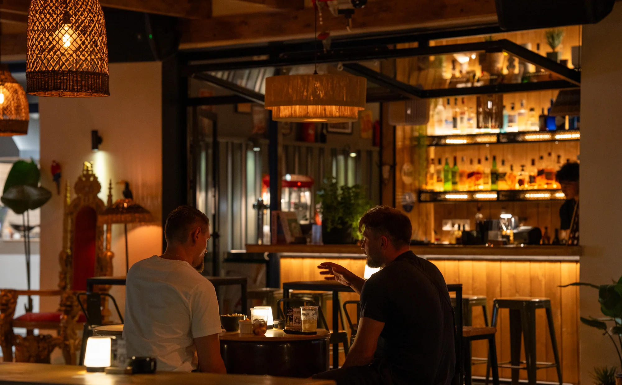 Guests enjoying drinks in the warmly lit bar at The Cup